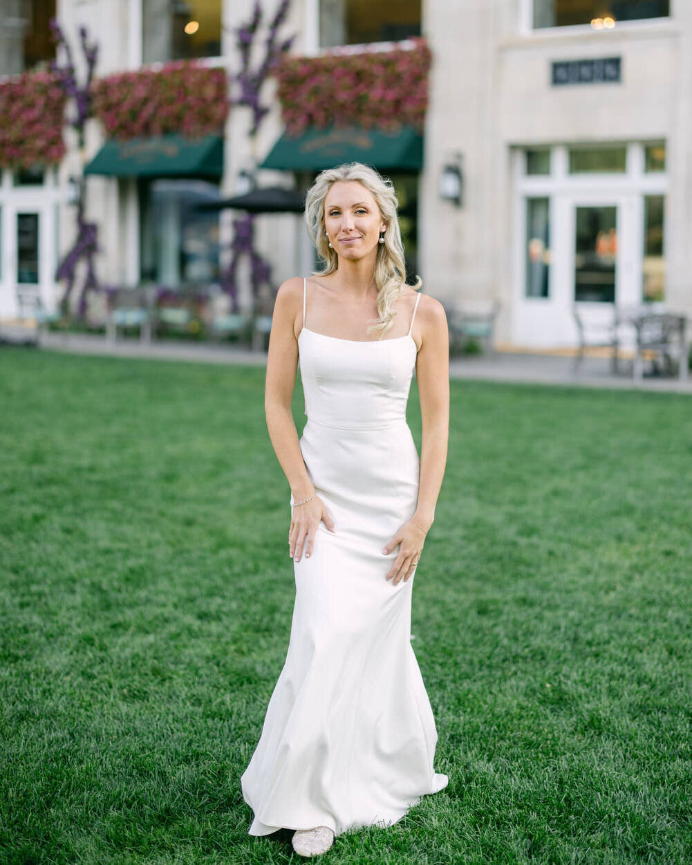 This stunning bridal portrait captures the bride looking elegantly at the camera while standing on the lawn of the Banff Springs Hotel. The luxurious surroundings and her poised demeanor create a timeless and sophisticated moment, reflecting the beauty and grace of her wedding day.