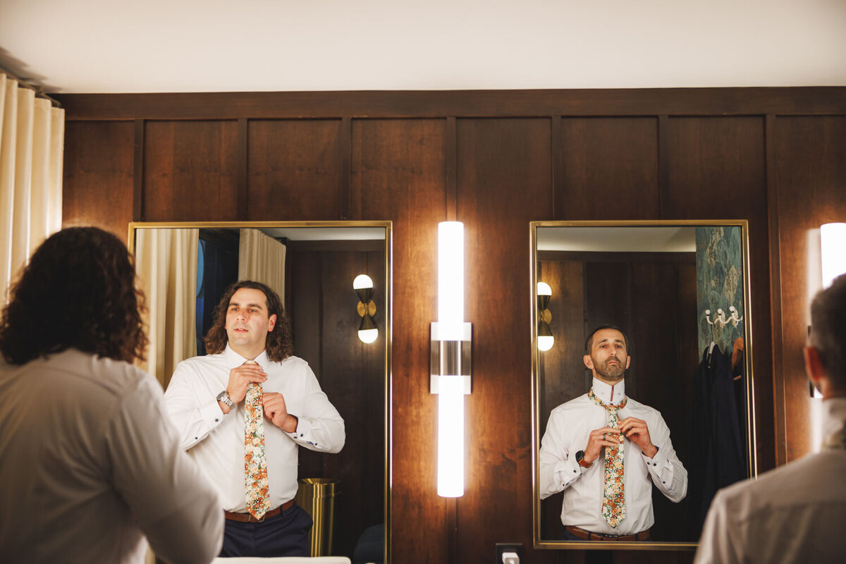 Groomsmen fixing their self in front of the mirror