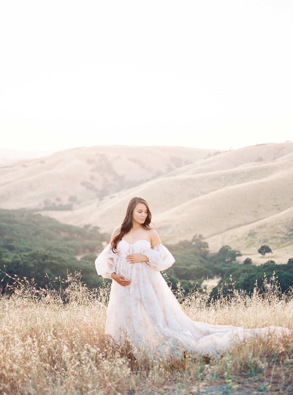 Pregnant woman framing her belly in a tulle dress taken by San Francisco Maternity Photographer Laurel Smith.