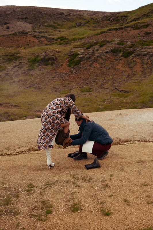 Model is putting on shoes on a location photoshoot in nature