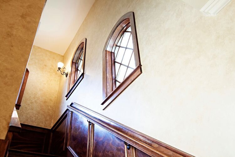 windows over staircase in medieval styled home.