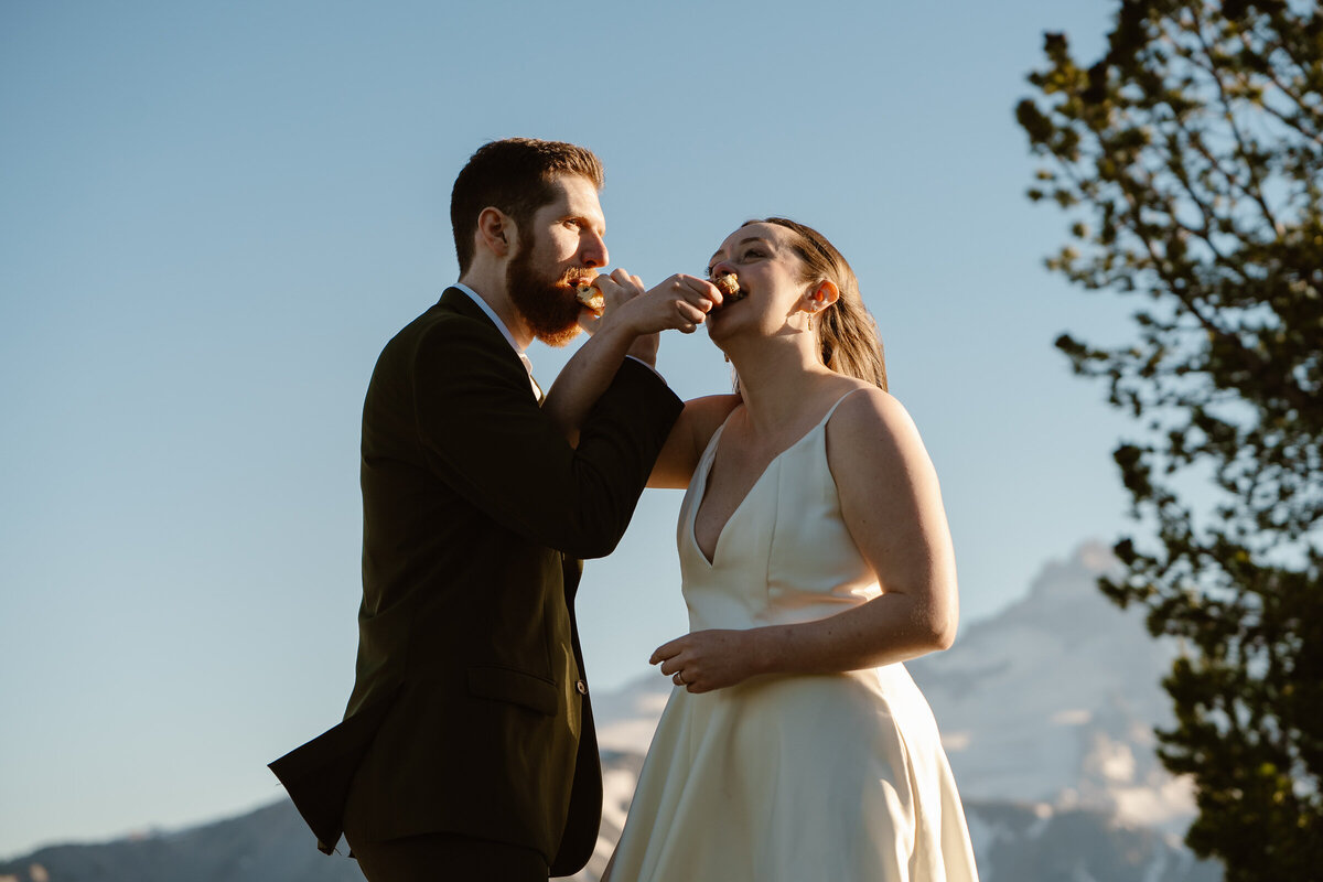 a bride and groom feed each other dessert at their washignton elopement