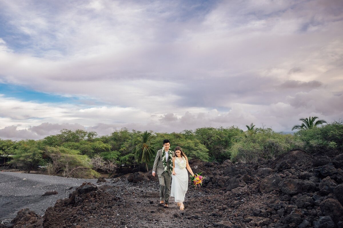 bride and groom hiking on lava field trails