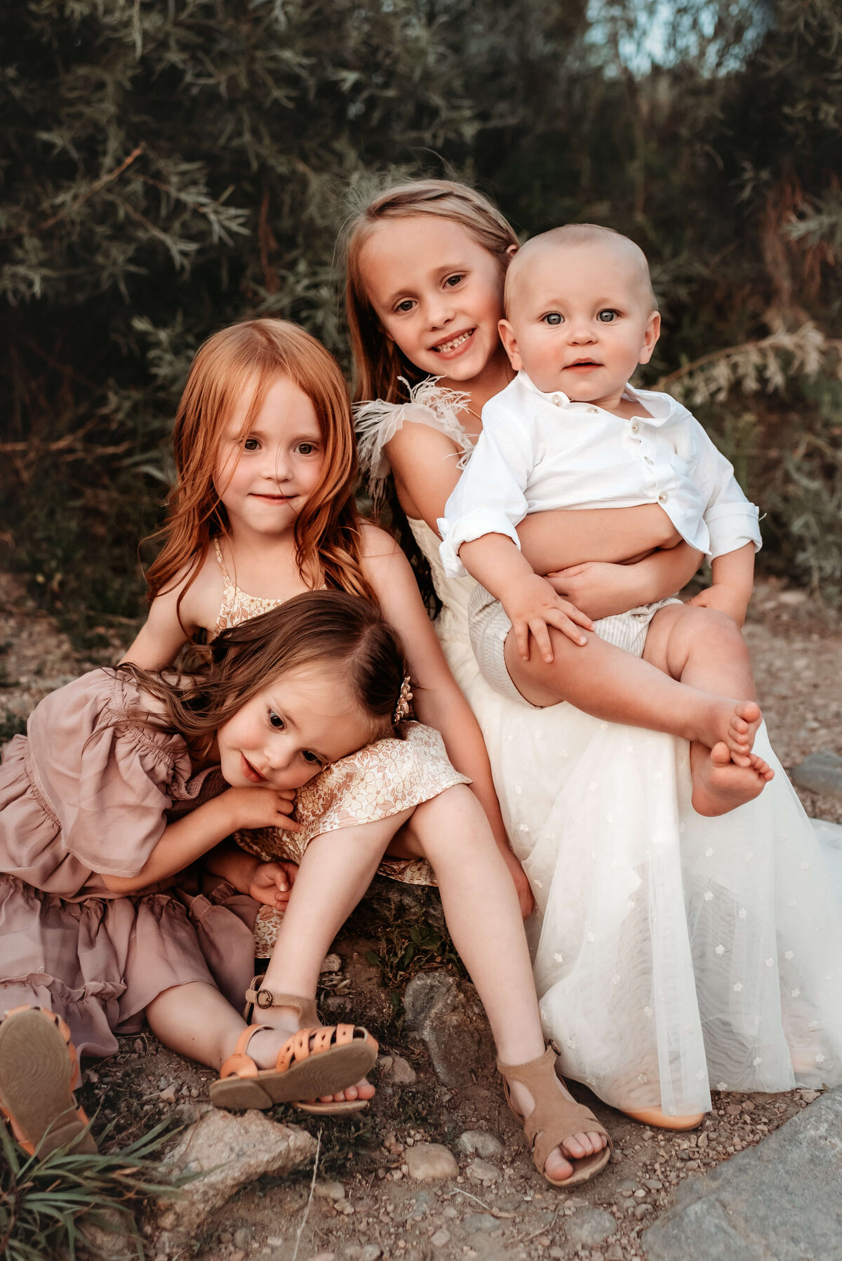 denver family photography of four siblings sitting on rocks
