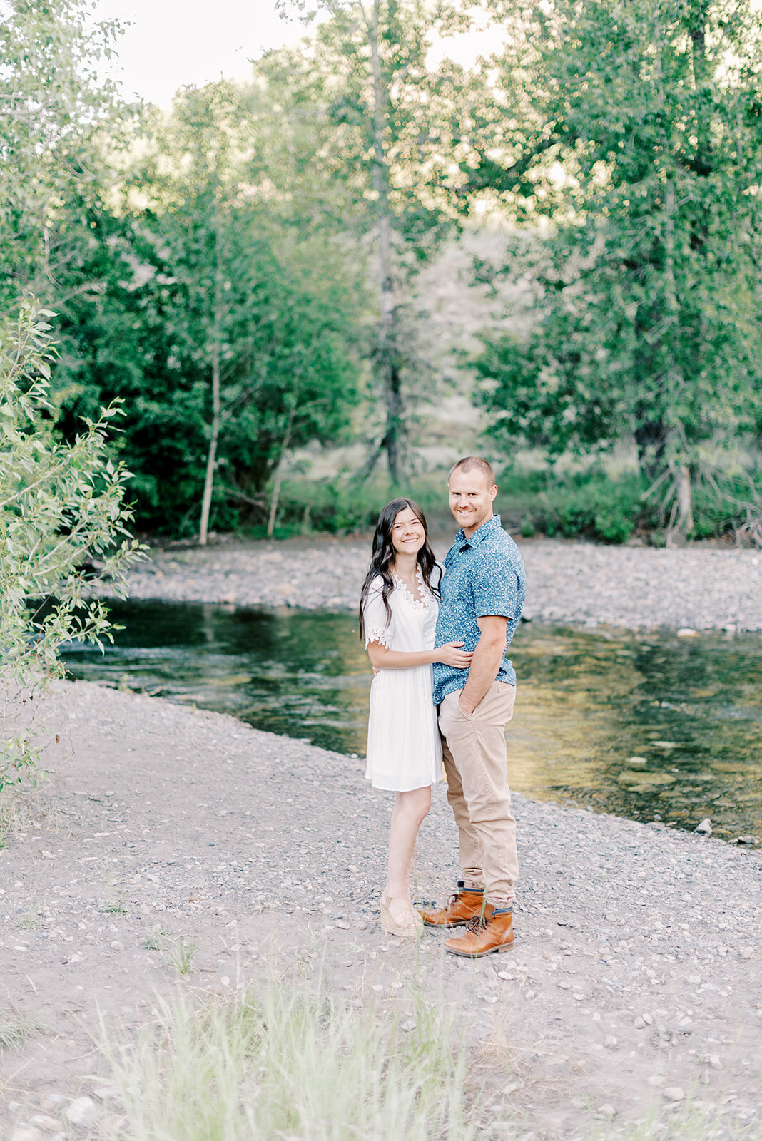 Couple standing in front of river at Sun Valley Engagement Session with the Best Sun Valley Wedding Photographers