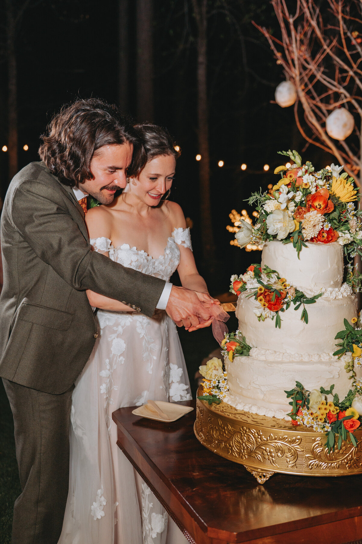 Newlyweds cut their wedding cake, smiling