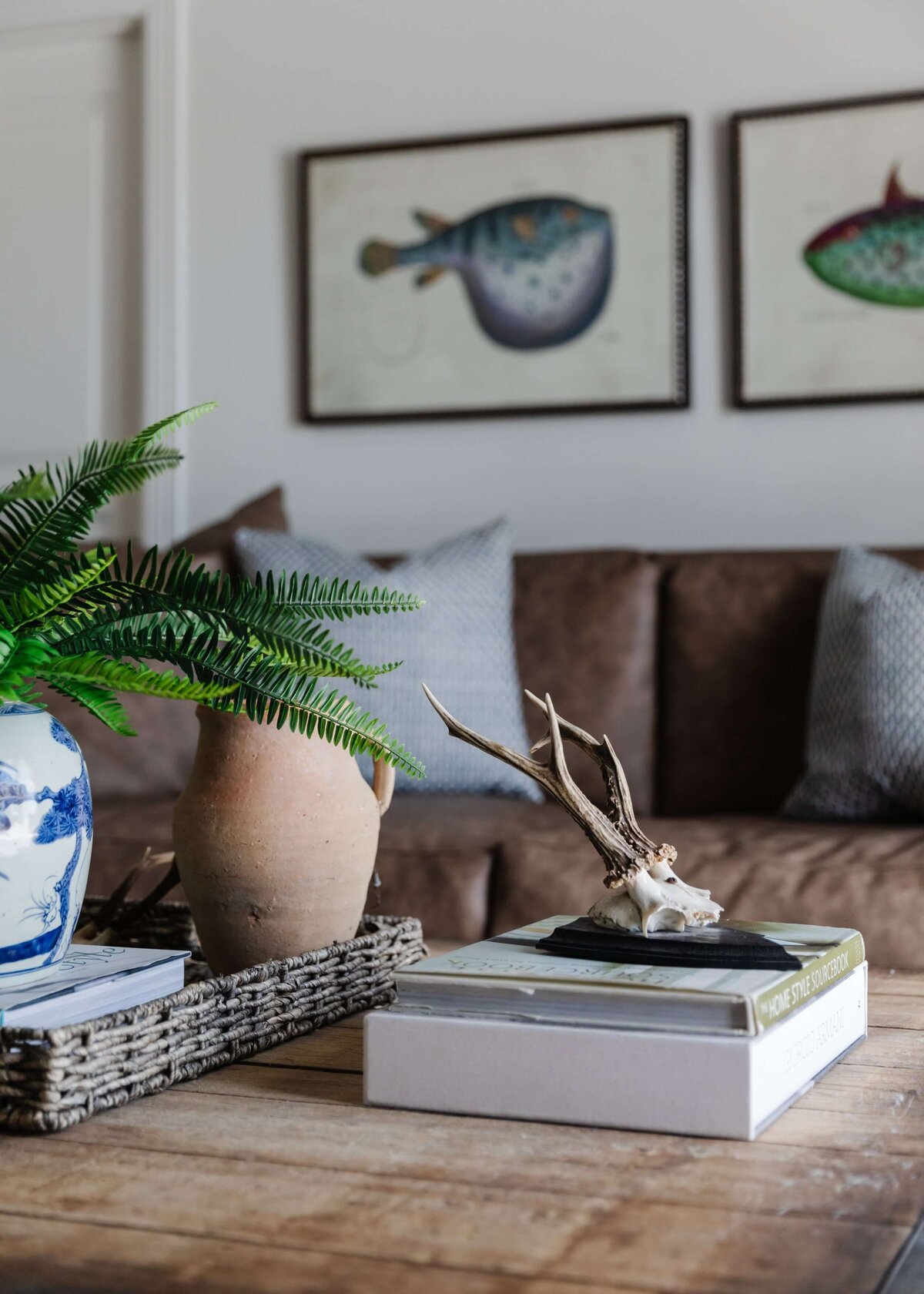 oyster creek studios home on the range fish artwork brown sofa and woooden coffee table with skull sculpture
