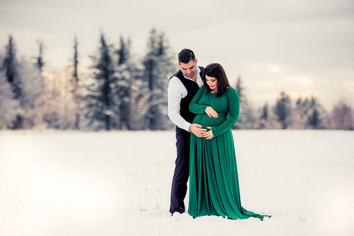 expecting couple in snowy field