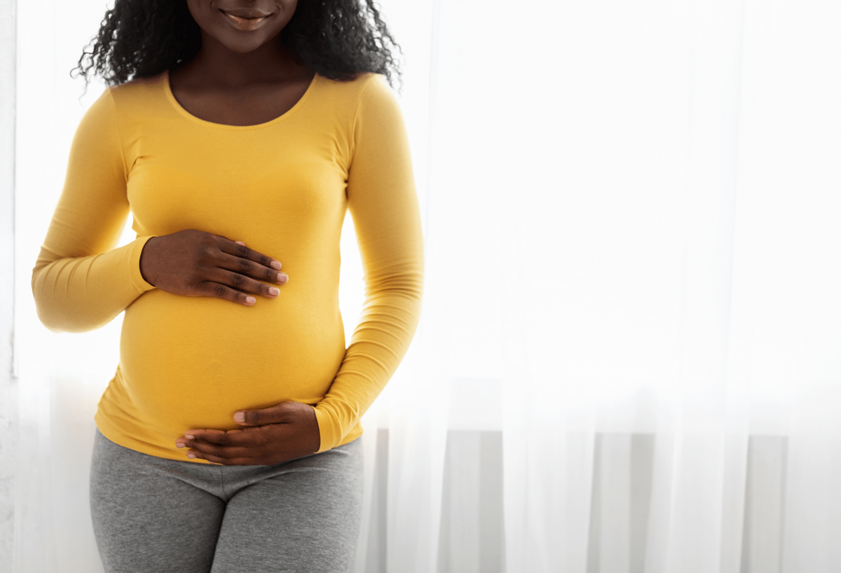 Woman of color holding pregnant belly