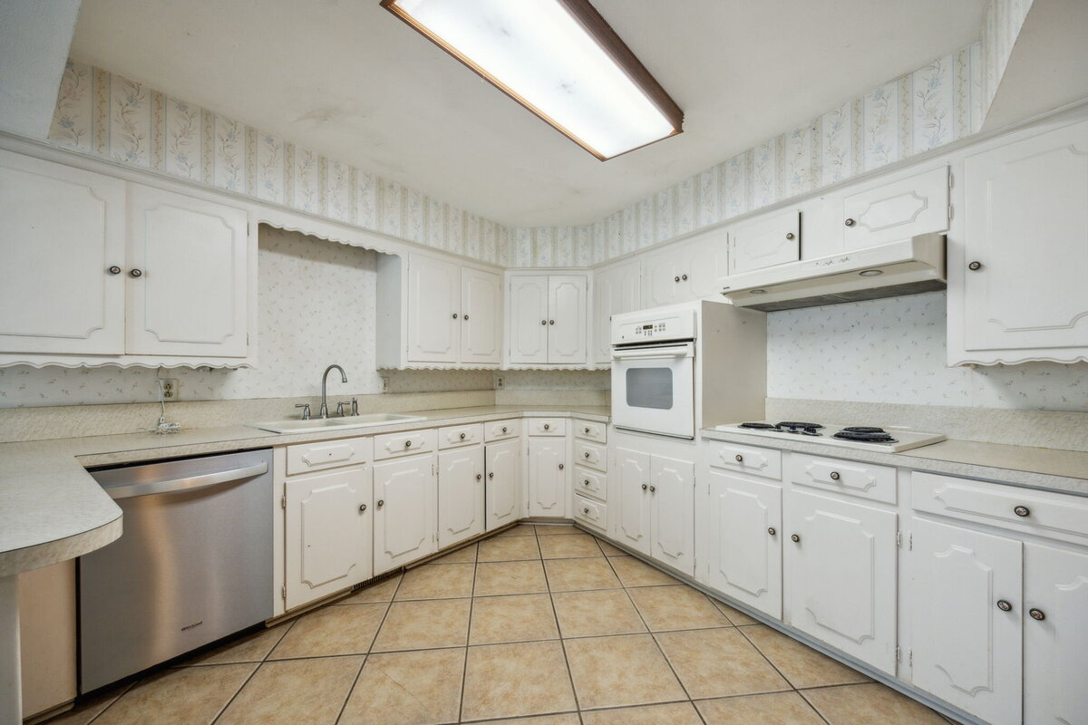 14214_edgecrest_dr_dallas_tx_kitchen_view_-vintage_white_cabinetry_with_tile_flooring_and_gas_range-_haven_realty_group