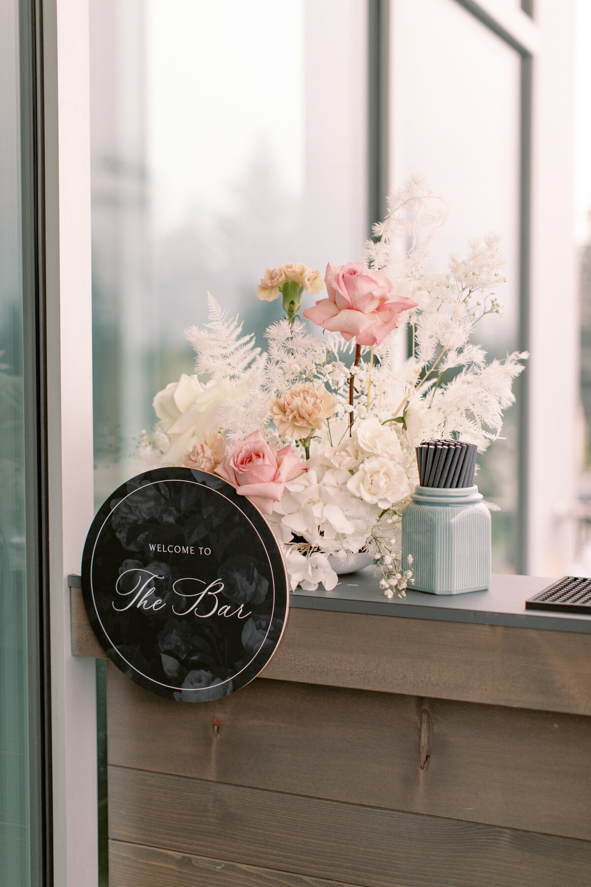 Modern Chic Wedding at The Sensory in Canmore Alberta, designed and planned by Rebekah Brontë, with a colour palette of fresh white, smoke grey, blush pink, and subtle seafoam - modern wedding  bar sign and floral arrangement