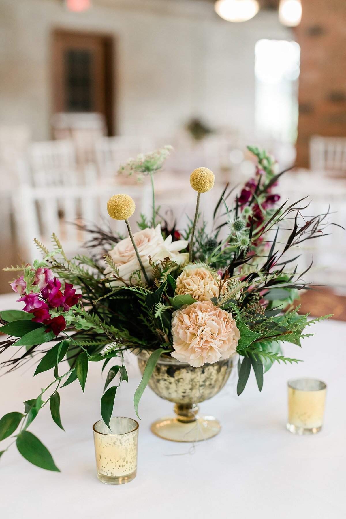 Fall inspired floral table setting in a gold wide vase.