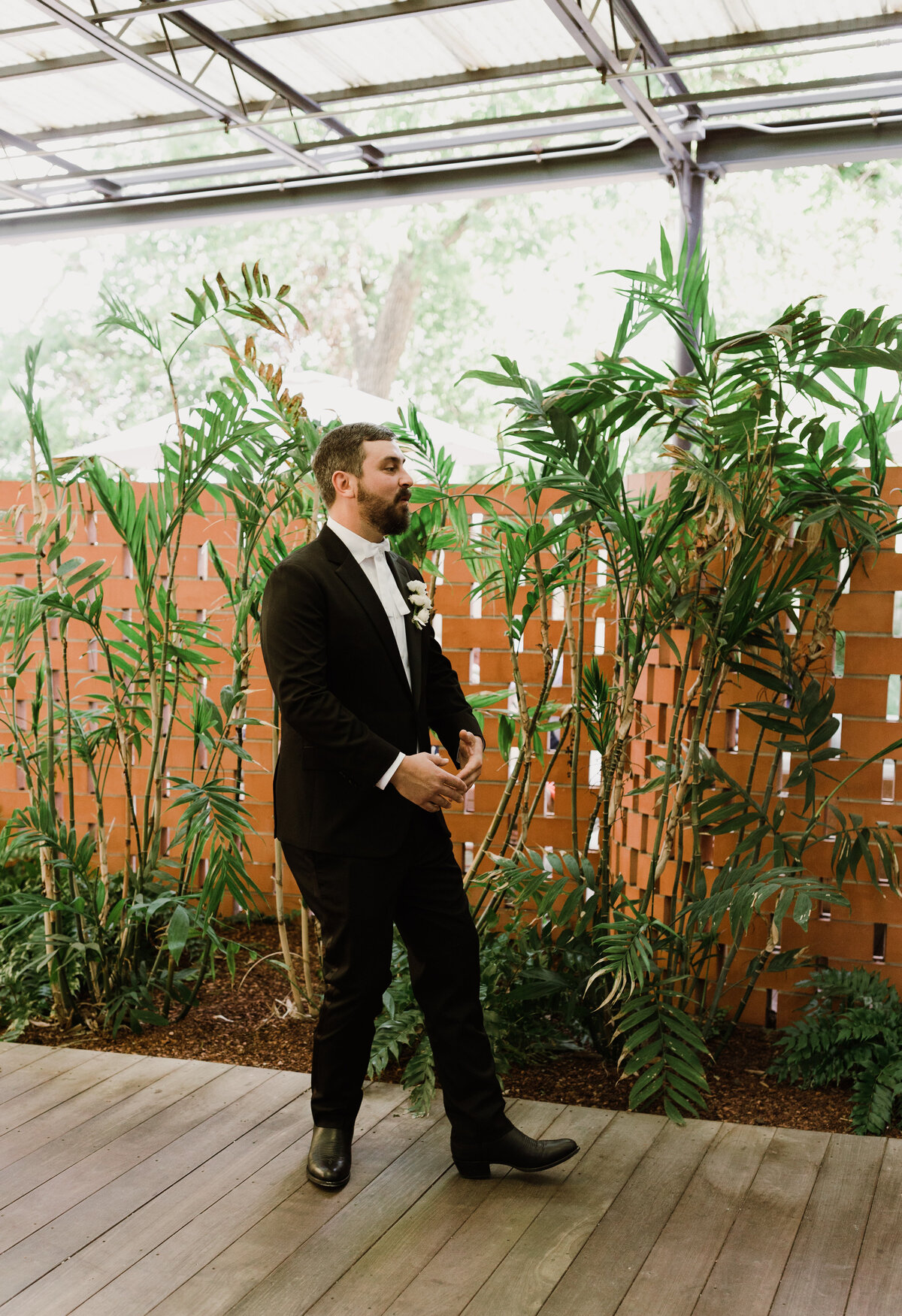 Groom standing by plants at  Carpenter Hotel, Austin