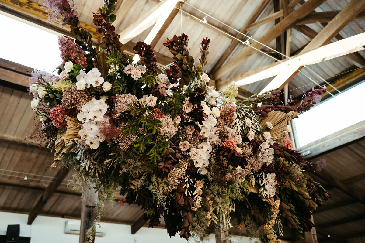 Large hanging floral installation at Stones of the Yarra Valley with massed moody toned blooms