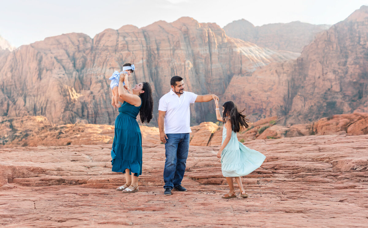 mom and dad and kids playing a game with a blanket