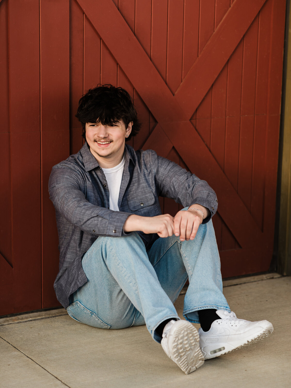 male high school senior in blue button down posed at Westcreek reservation for senior portraits
