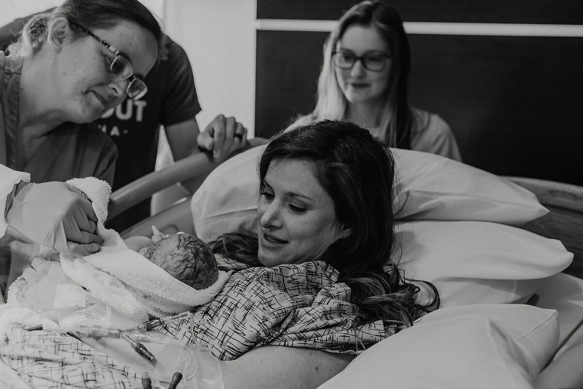 Mom Holds Newborn Baby in Hospital Bed