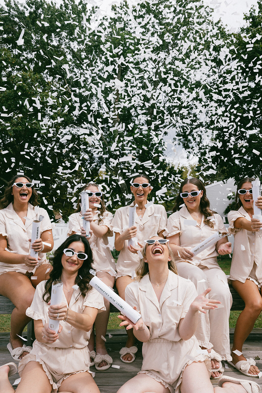 Bridal party smile in delight as their confetti falls during their bridal party photos. 