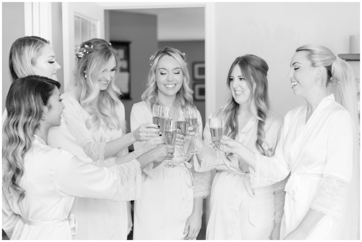 Light-and-Airy-Ottawa-Wedding-Photographer-bride-and-bridesmaids-drinking-champagne