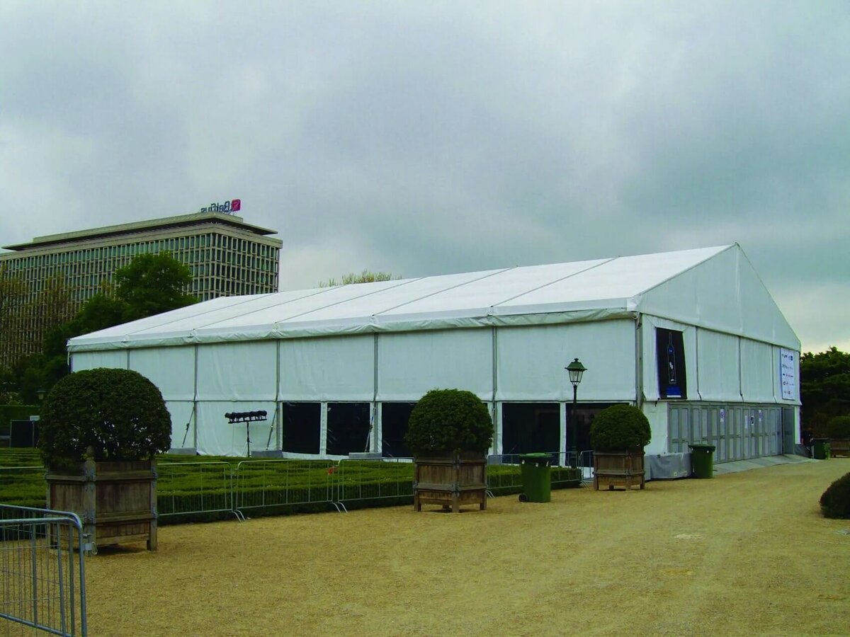 A very large frame marquee with hedges in front of it