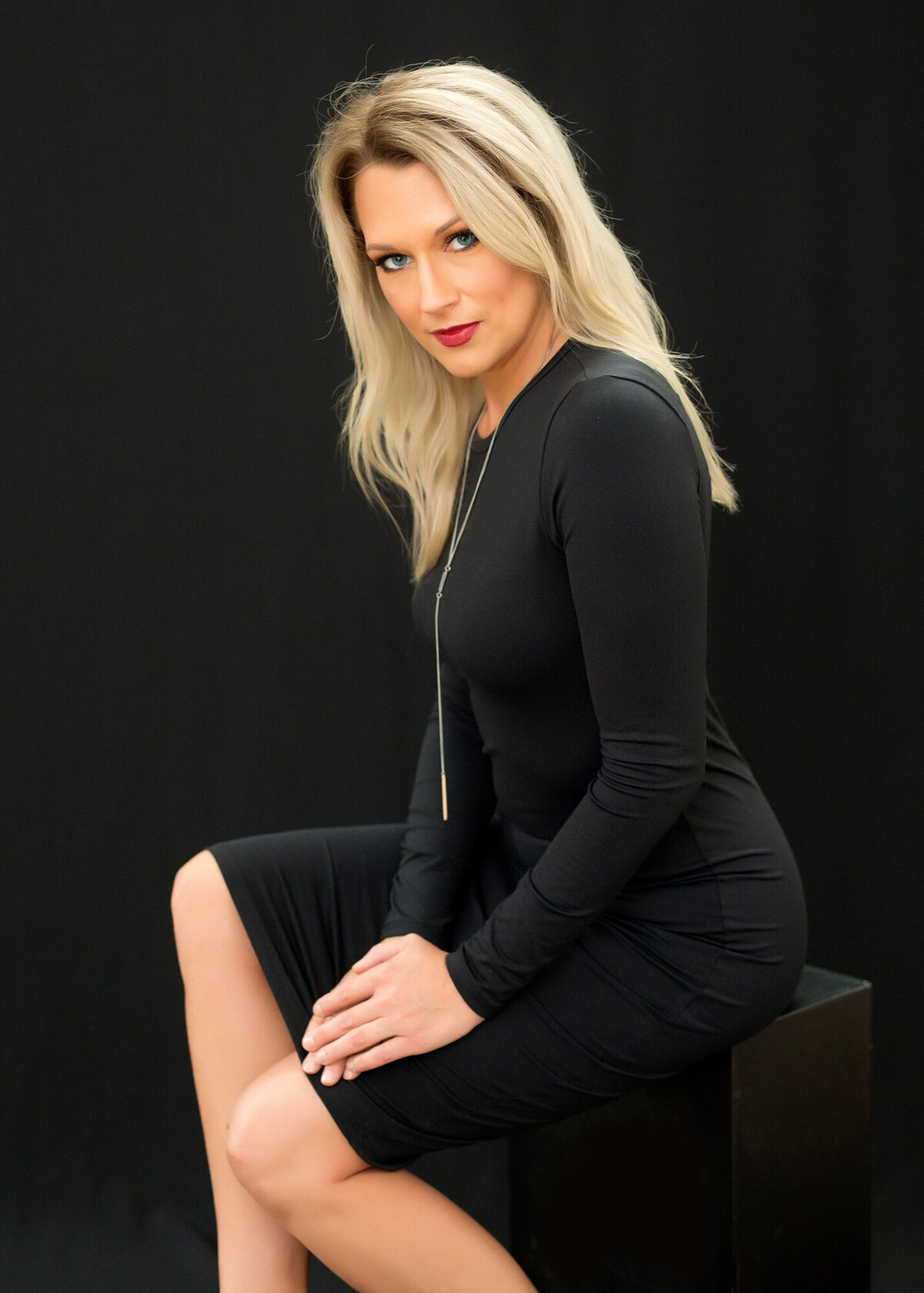 Headshot image of a woman wearing a black dress, seated