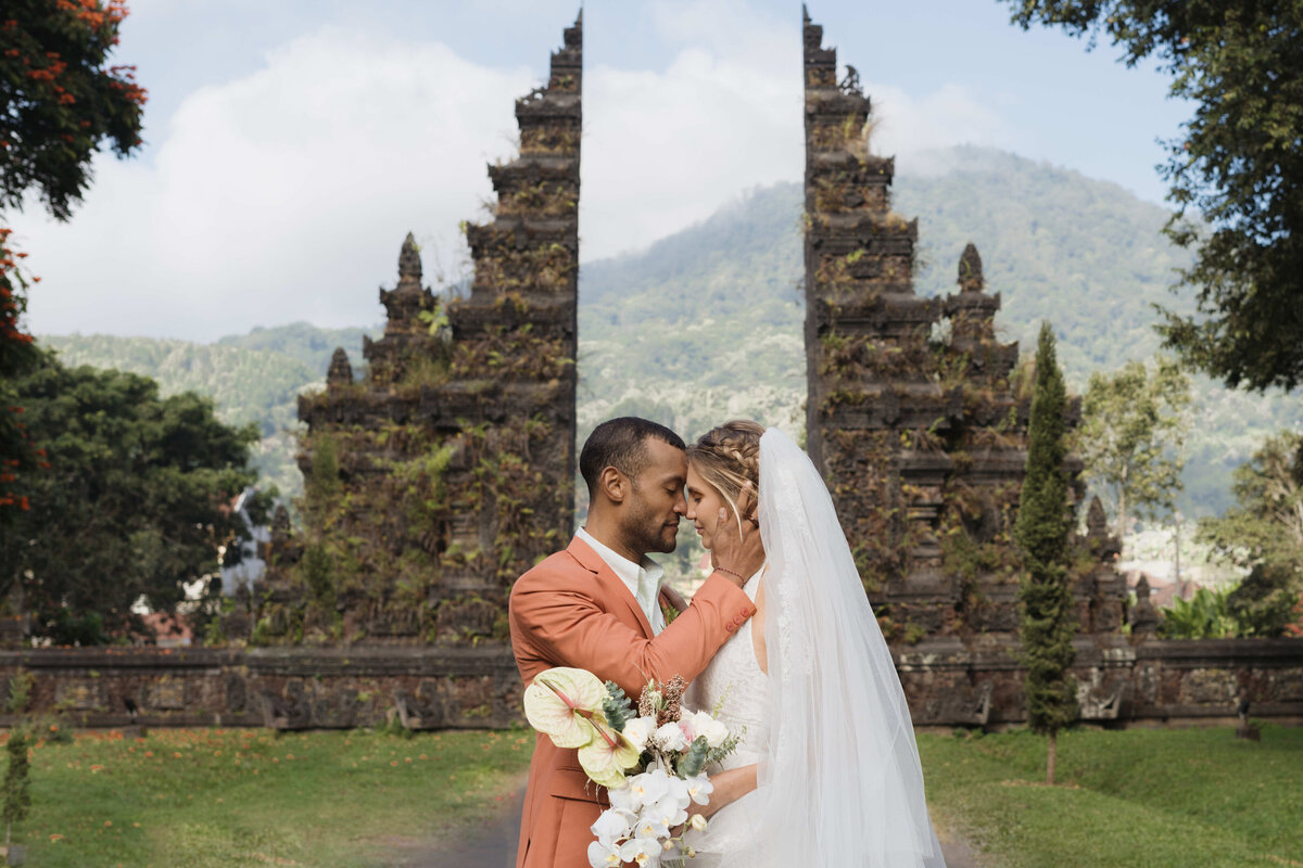 Couple just married in Bali with some of the most iconic architecture behind.