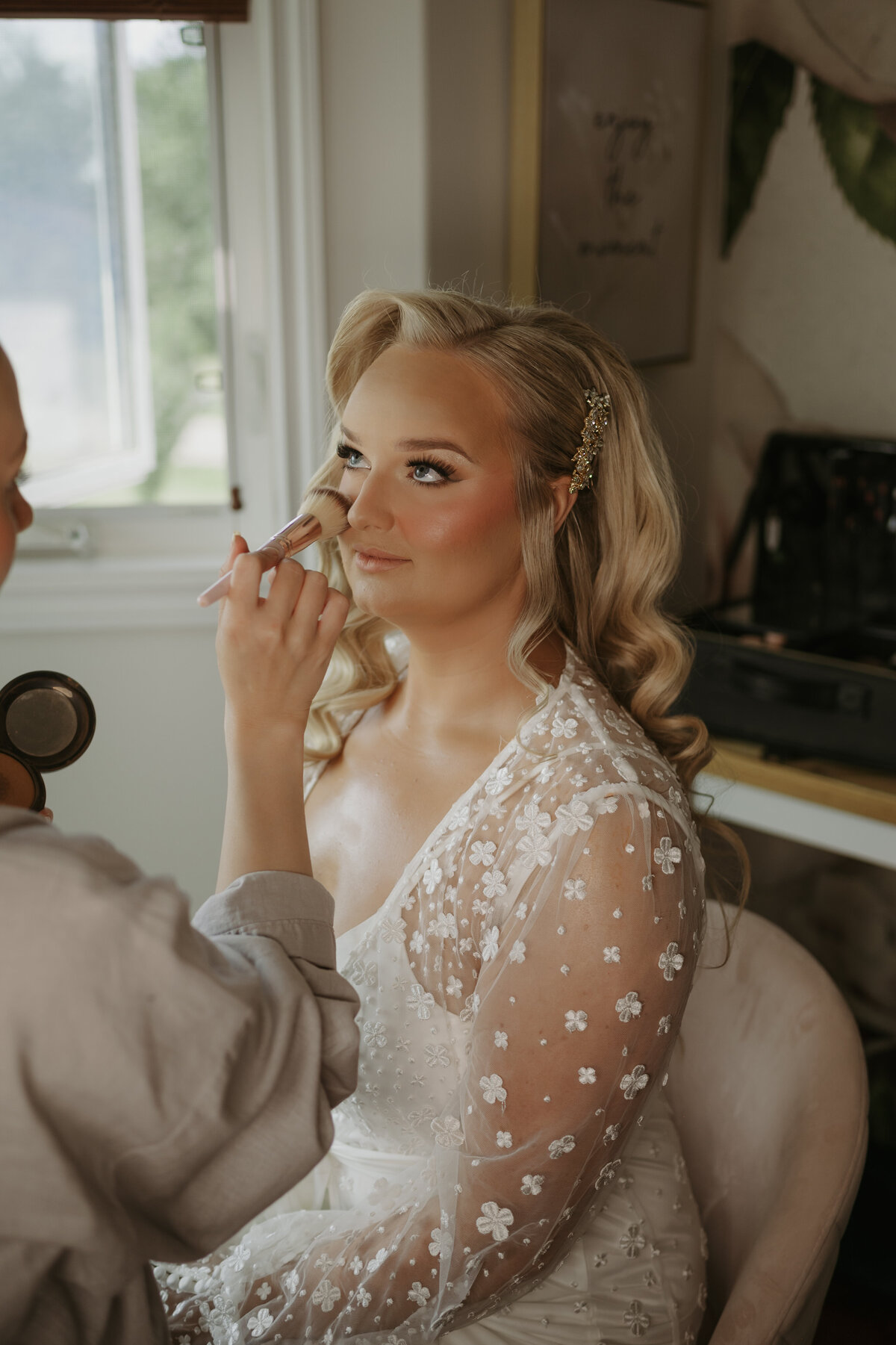 bride getting makeup touchups wedding morning