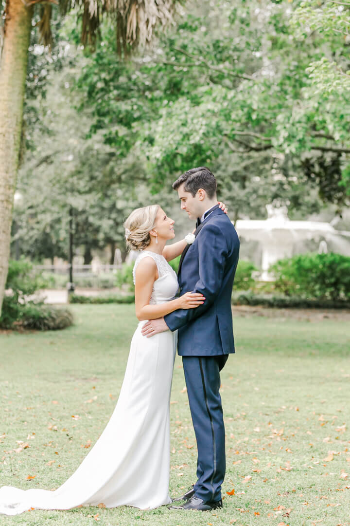 Groom and Bride embrace each other in Forsyth Park, Savannah, GA.