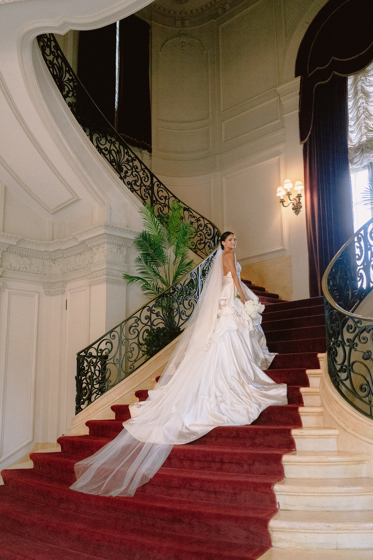 A bride on the interior staircase at Rosecliff Mansion
