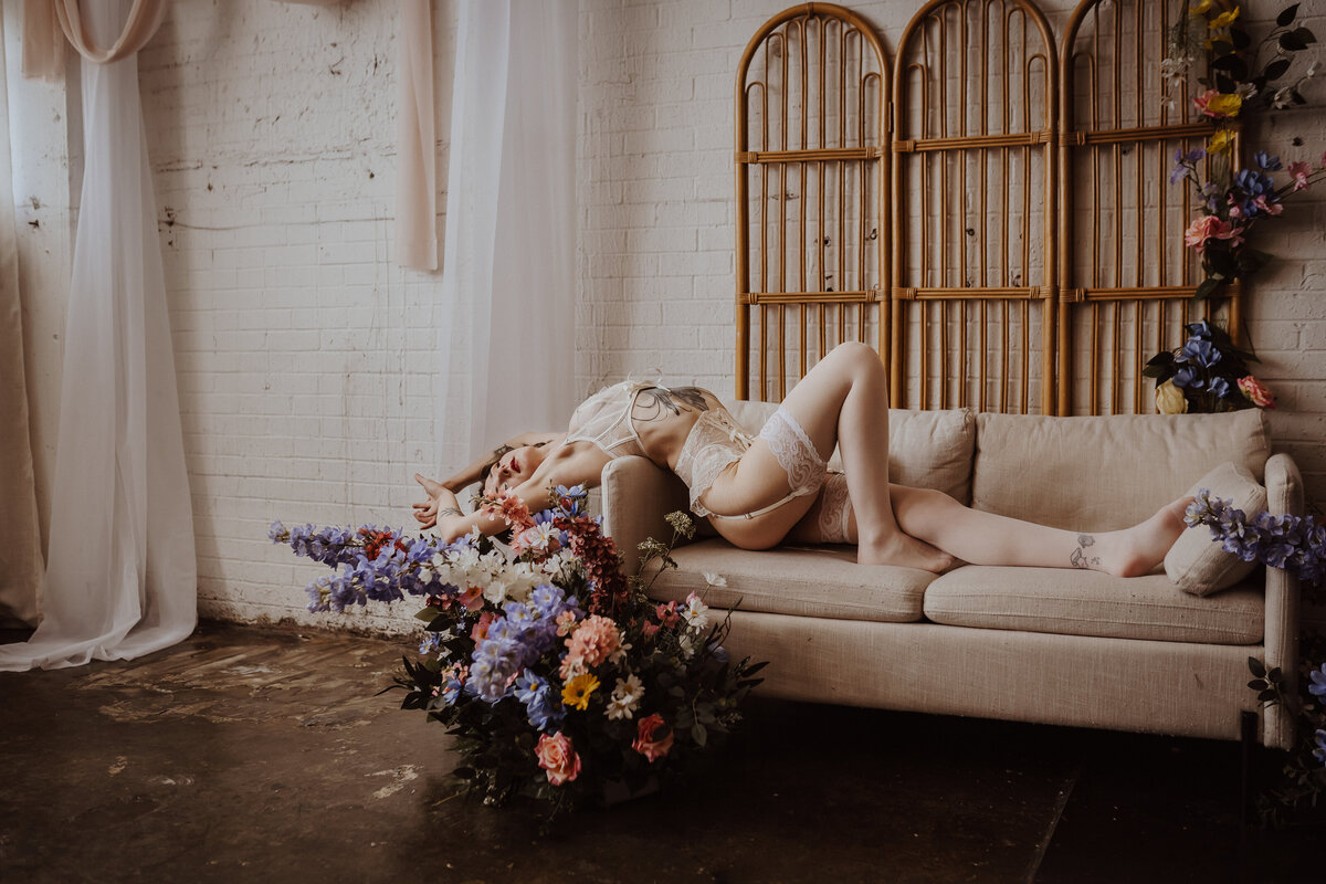 romantic-bridal-boudoir-on-couch-with-flowers-des-moines-storyteller-studio-storyteller-collective-photo-co