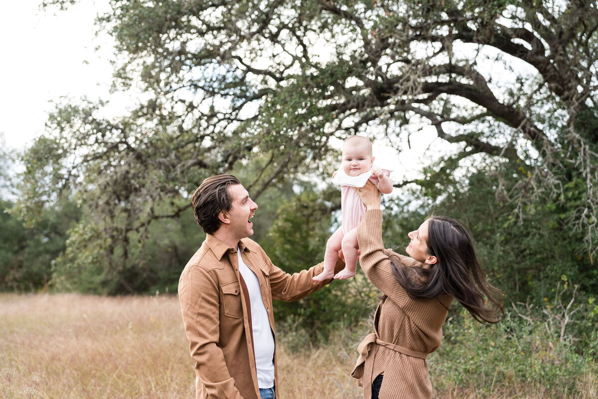Family plays during a family photoshoot at Circle C Park in Austin, Texas.