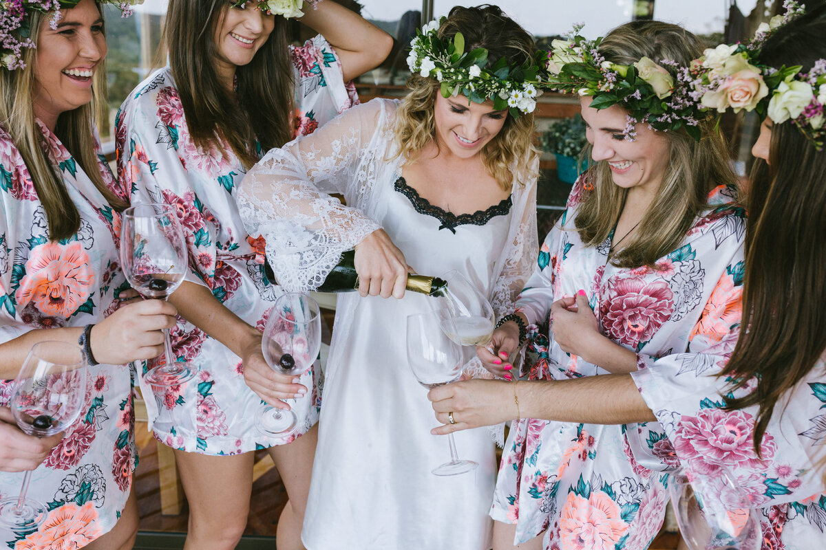 Bridesmaids raising glasses of champagne before the ceremony, smiling and sharing a joyful moment.