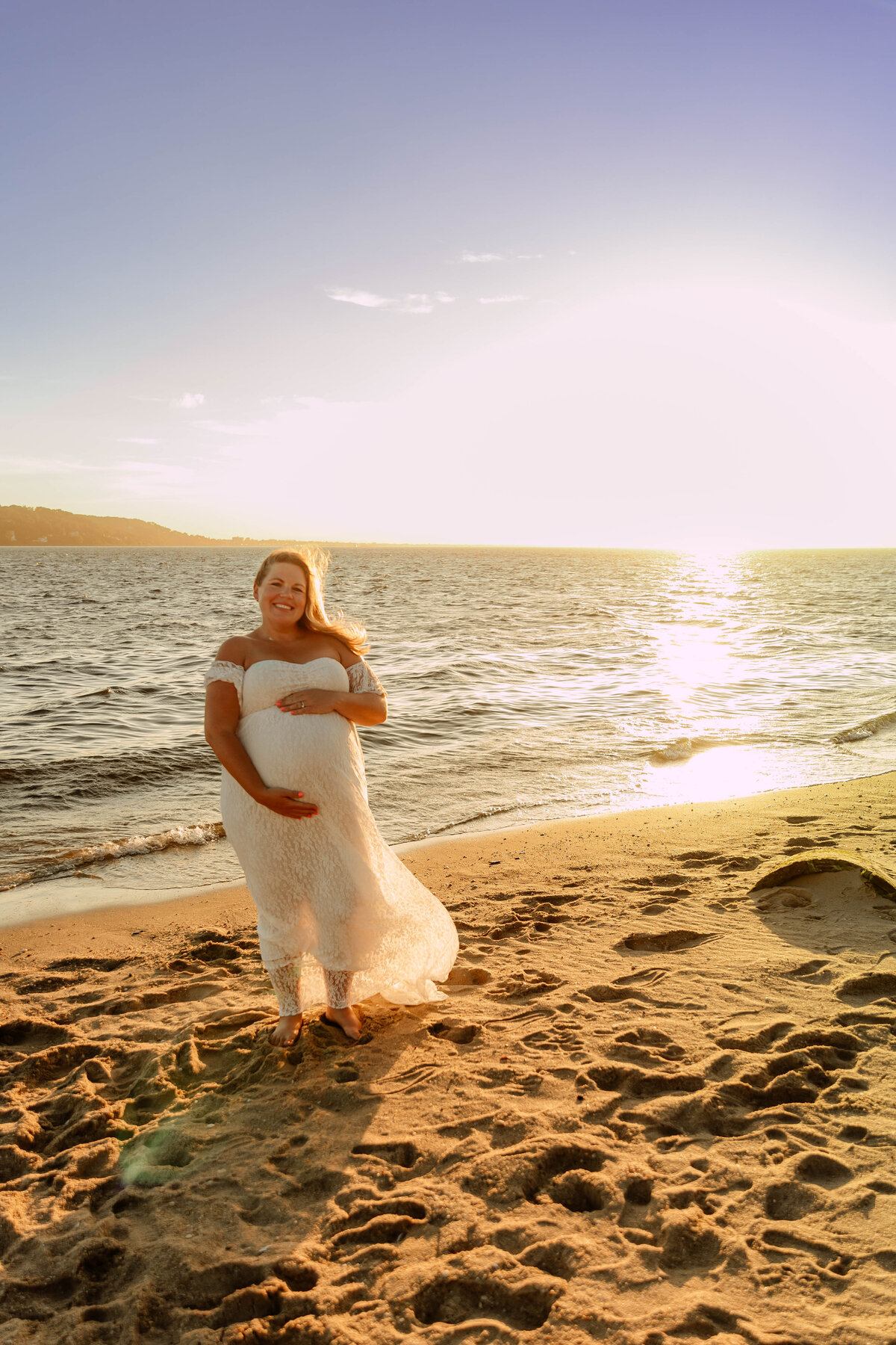 a pregnant woman posing at Sandy Hook Beach in NJ