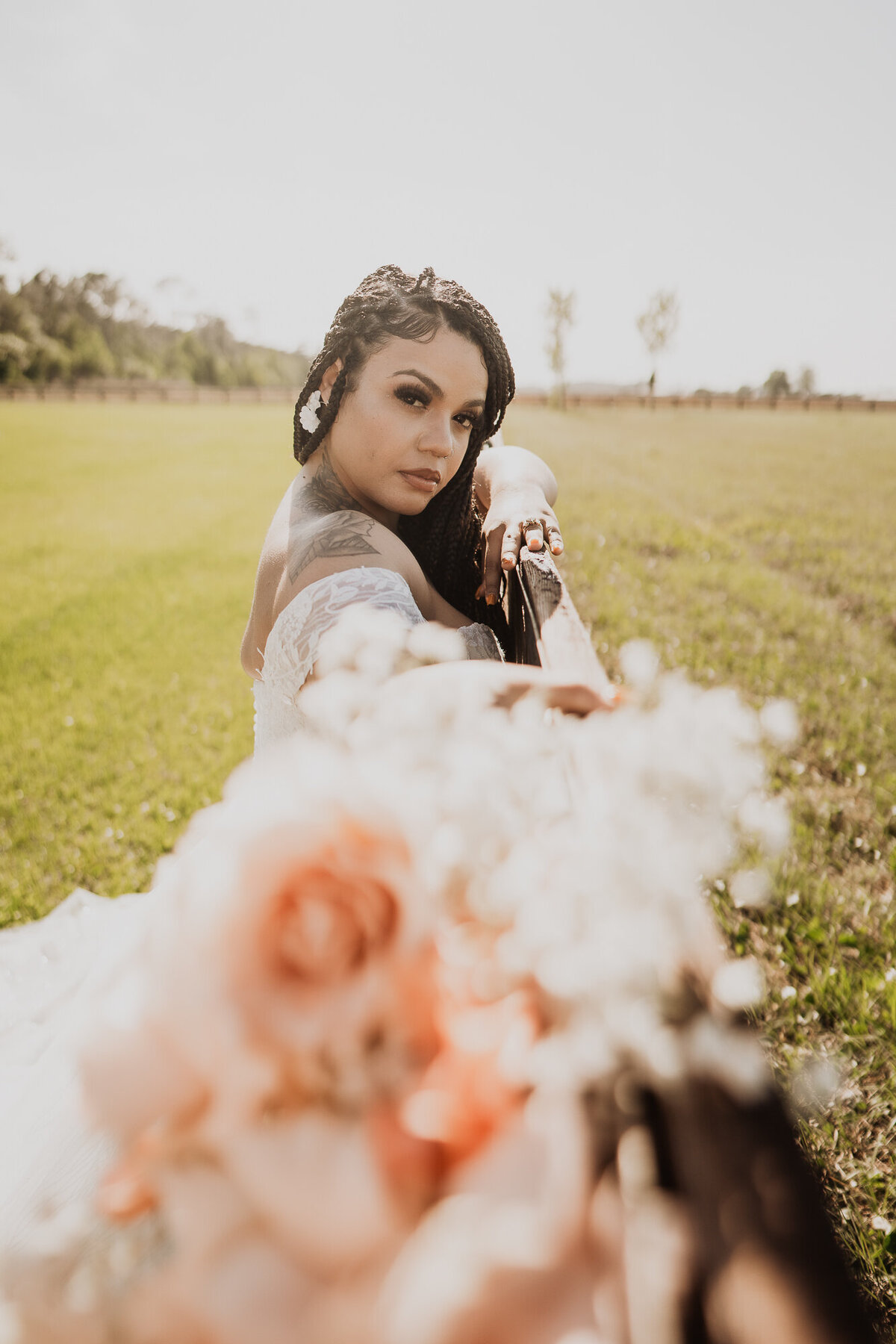 bride holding a bouquet pointing at the camera