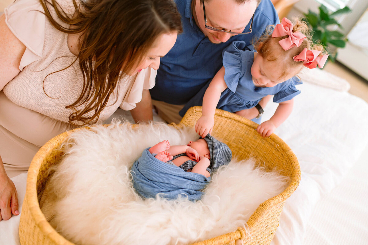 Parents gazing lovingly at their newborn during an in-home lifestyle session in Plano, Texas, captured by Jennifer L. Kirk Photography.