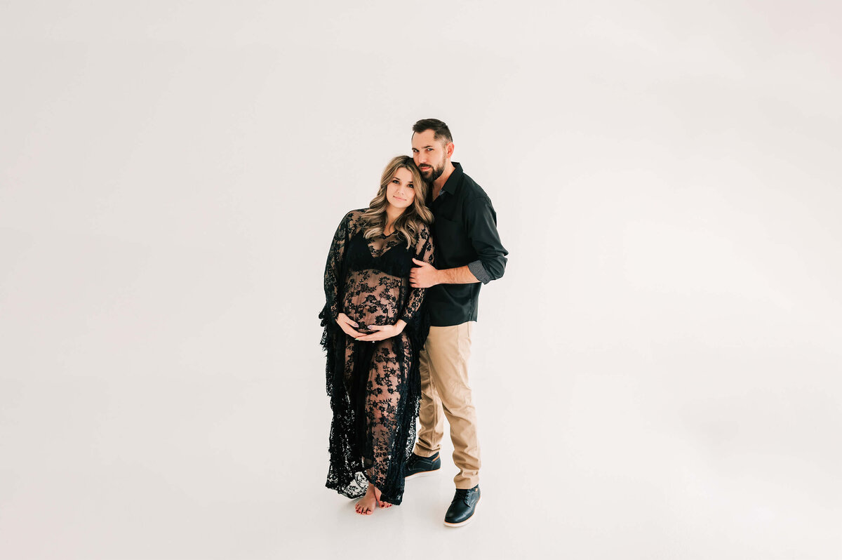 pregnant couple standing next to each other  during maternity photography session in Springfield MO