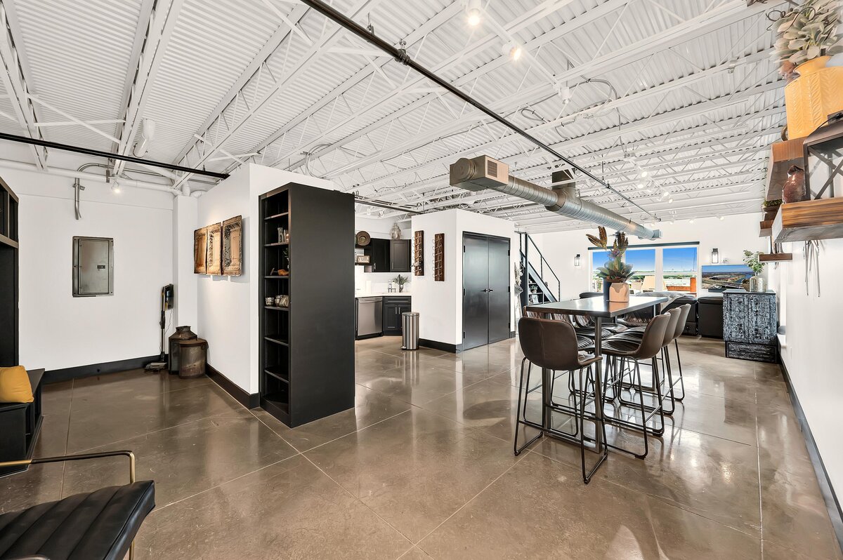 Open concept living and dining area in this two-bedroom, three-bathroom top floor corner loft in the historic Behrens building in downtown Waco, TX
