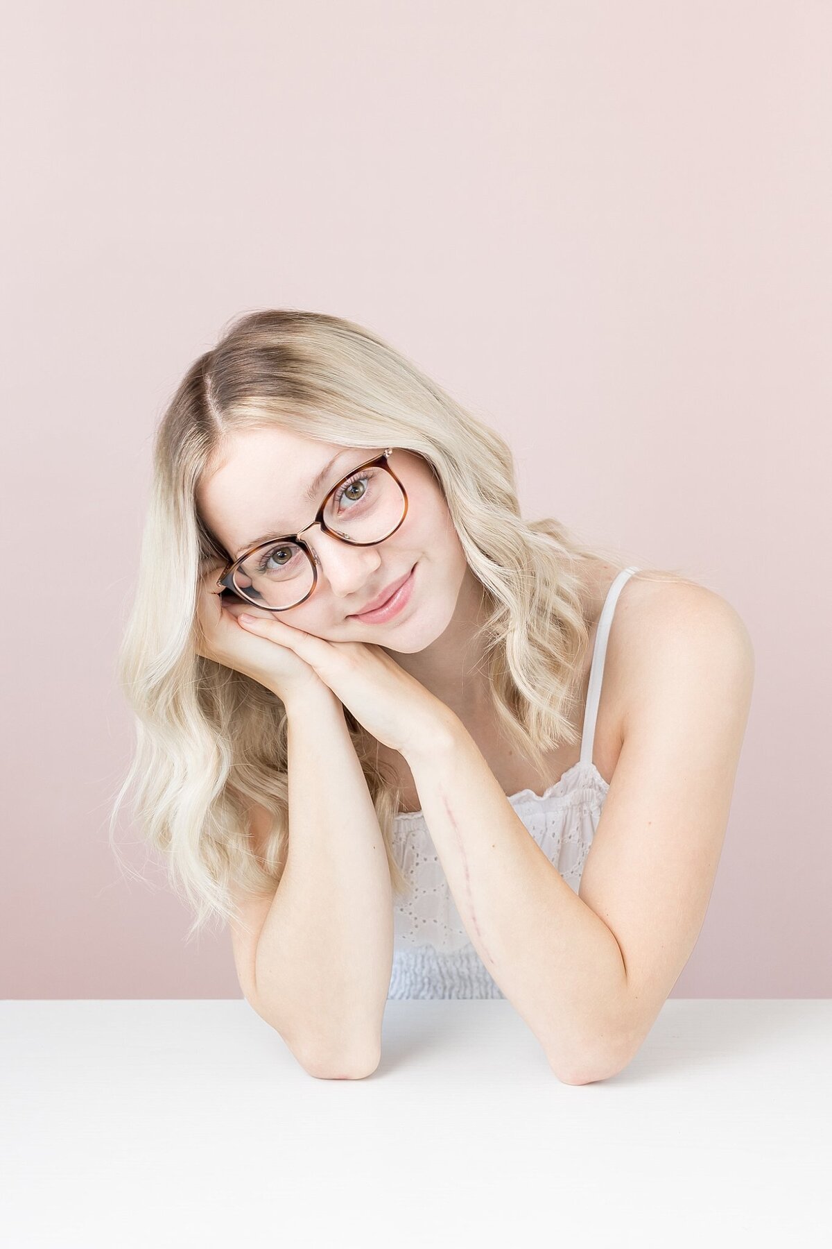 Teenage Female posing in front of a pink back drom