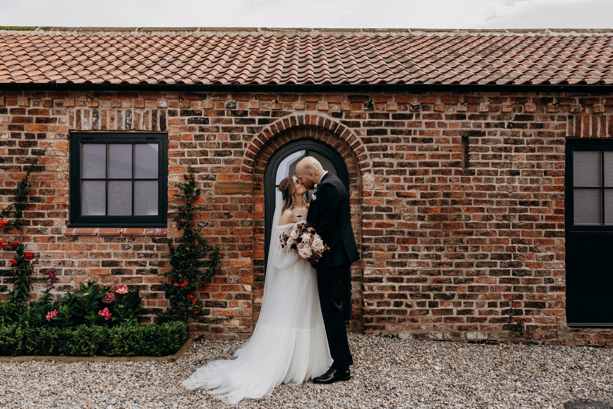 Bride and groom kissing at Thirsk Lodge Barn