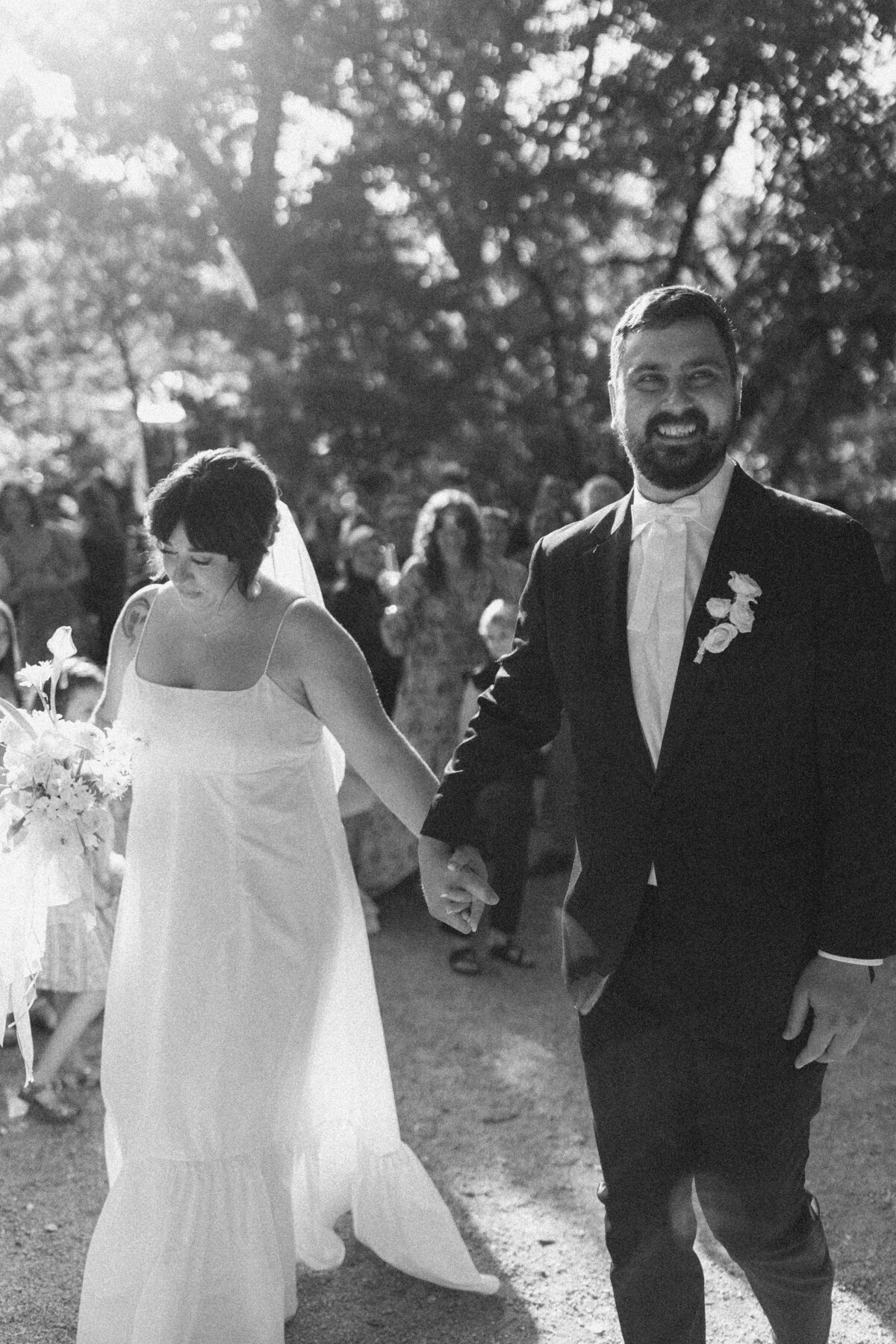 Bride and groom walking along just married at Umlauf Sculpture Garden, Austin