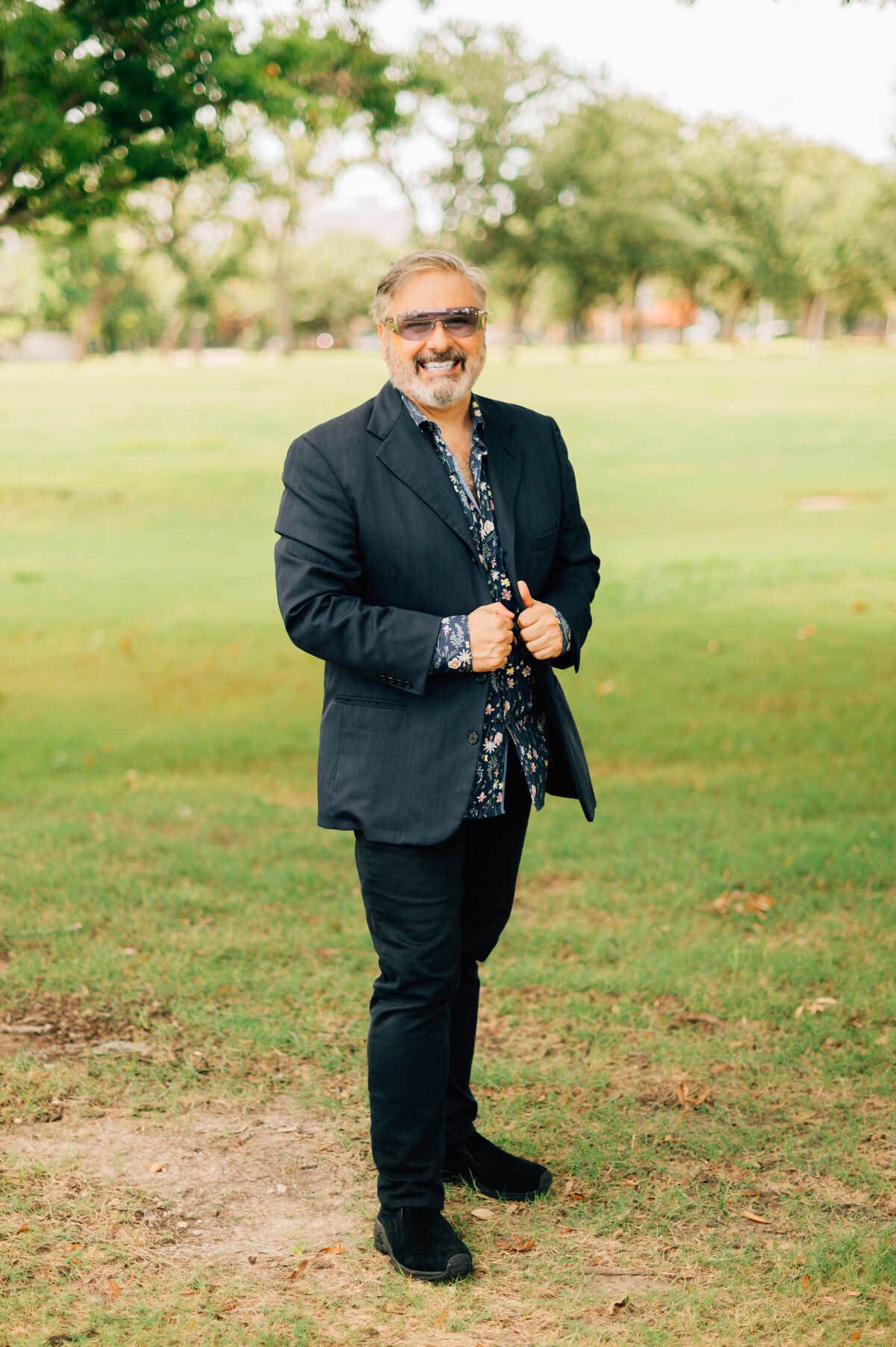 Ernie Manouse standing in open grassy area for professional branding session by Lissette G Photography in Houston
