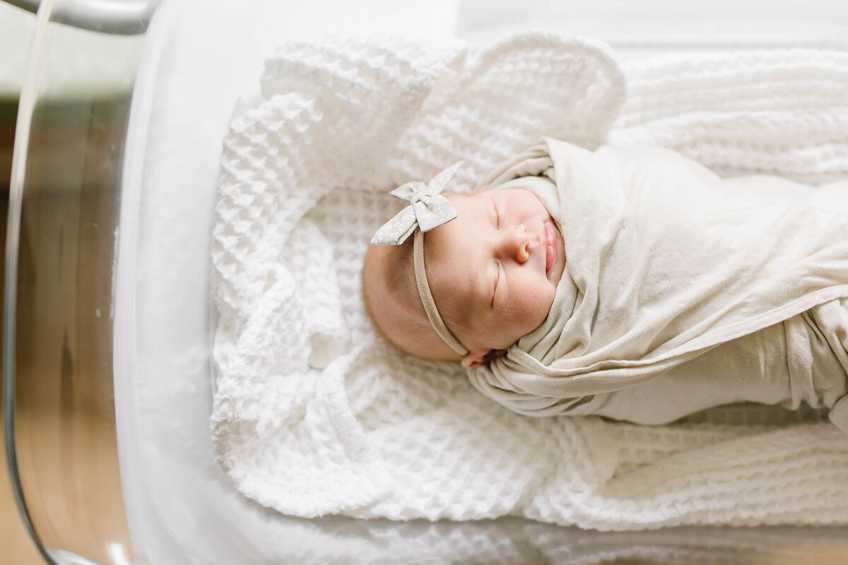 baby girl swaddled with bow on head