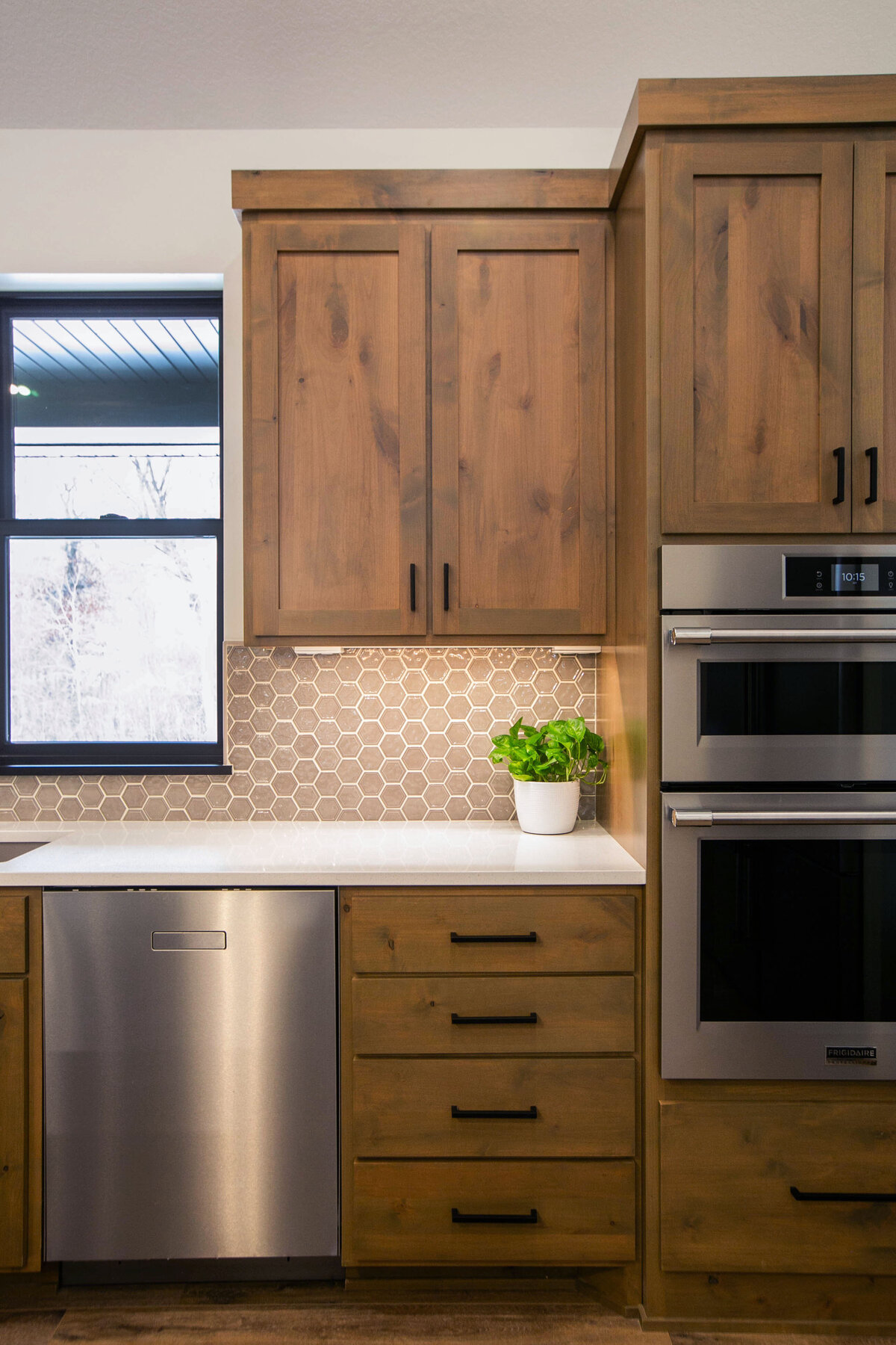 Open kitchen with dark cabinets, large island, and quartz countertops in an Elk River custom home
