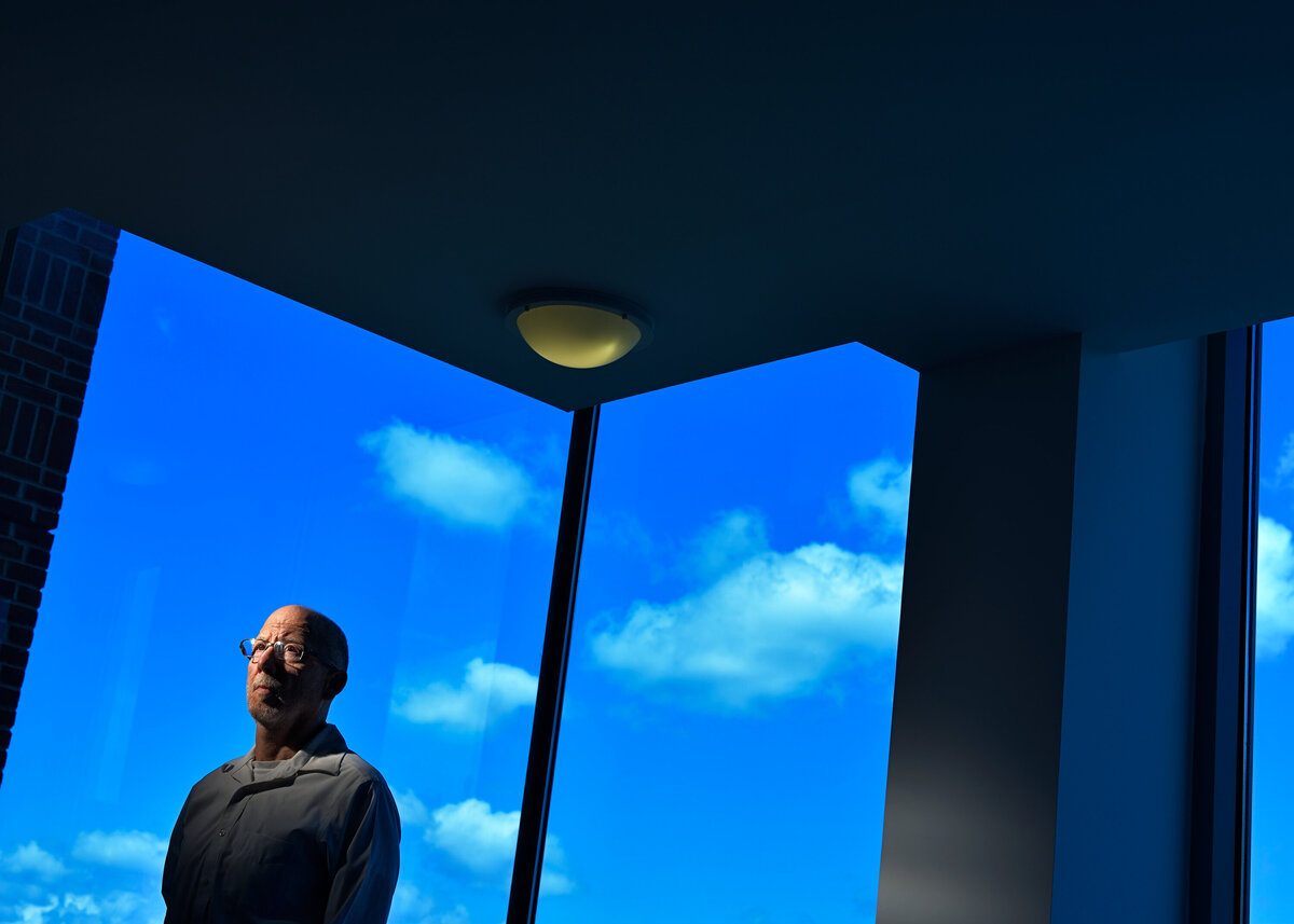 A man with cloud paintings behind him