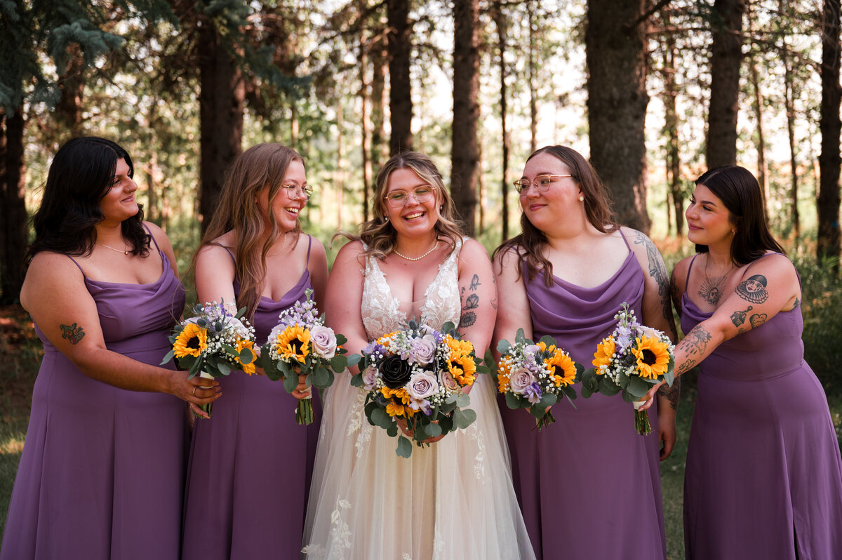 bride and 4 bridesmaids standing in a line with their bouquets for wedding portrait