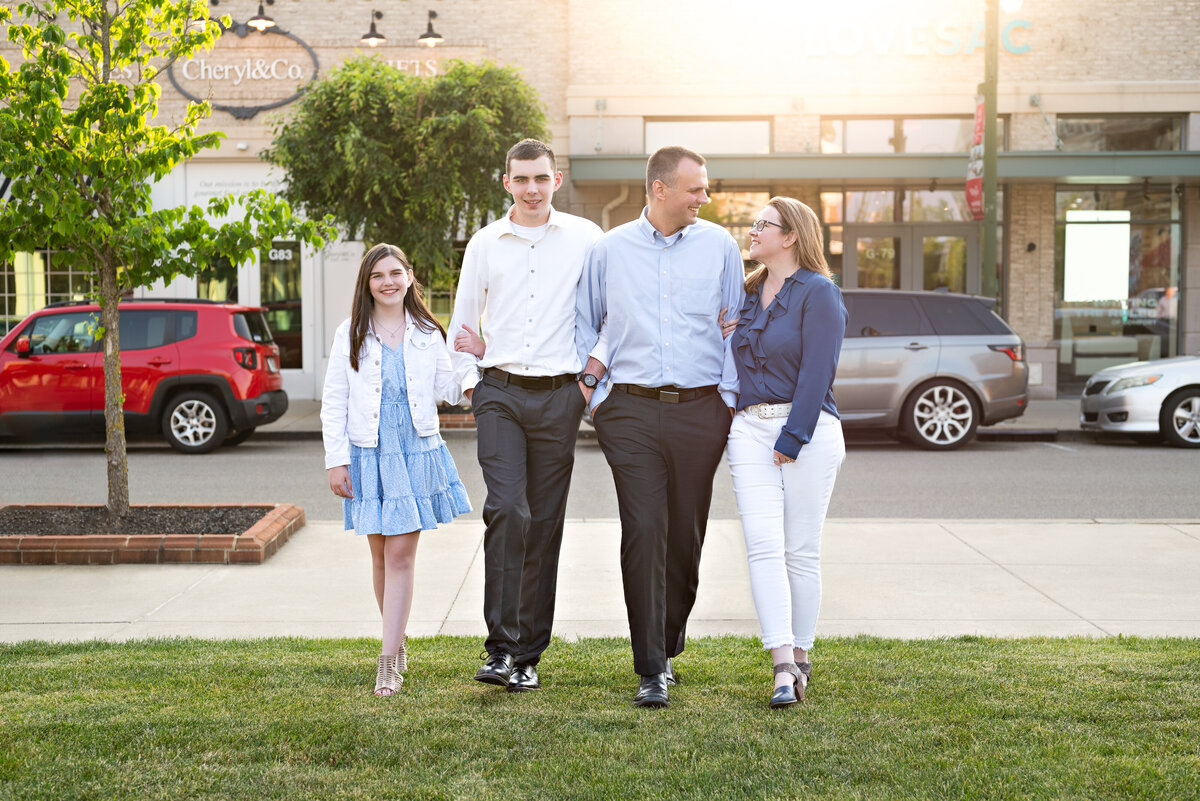 A family of four walk together in downtown Huntsville for family pictures