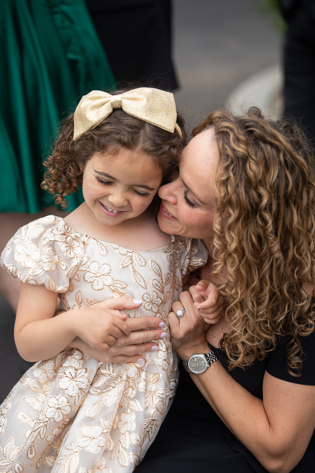 A person smiling with a small child in their lap laughing