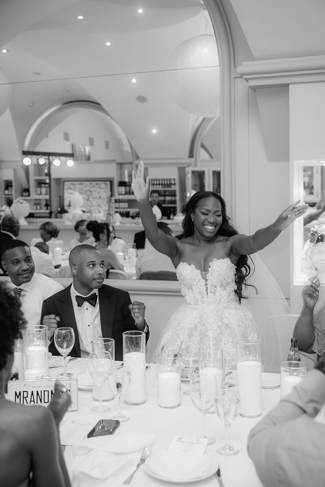Bride stands and cheers during dinner.