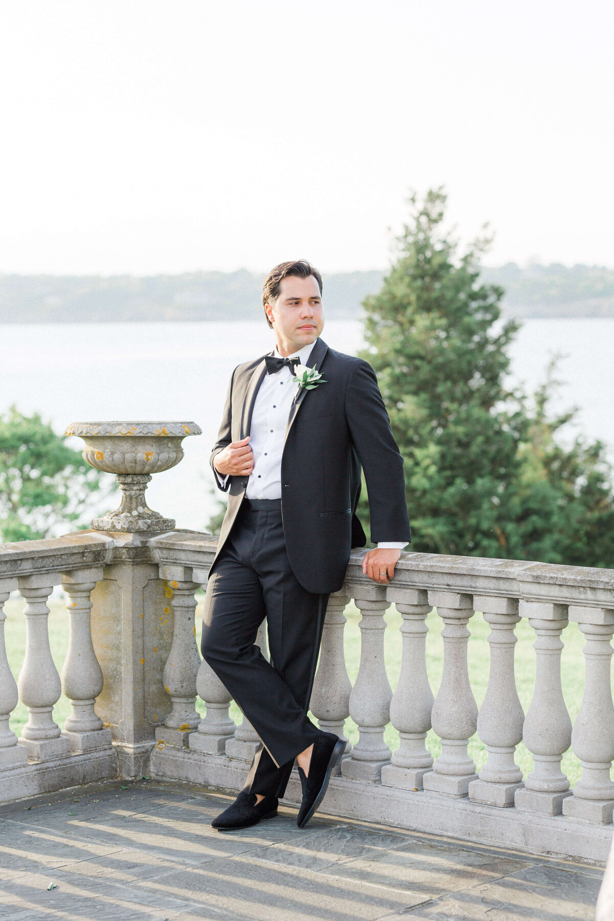 groom leaning on fence at castle hill inn newport RI