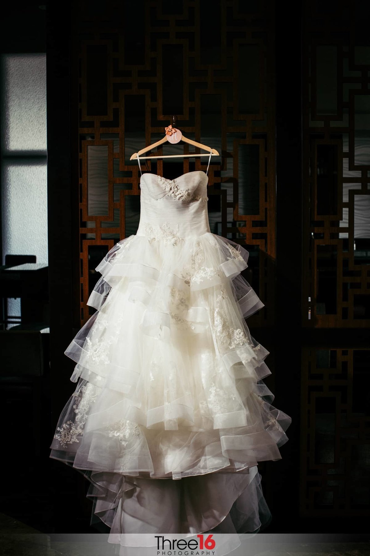 Bride's wedding dress hangs on display before she gets dressed